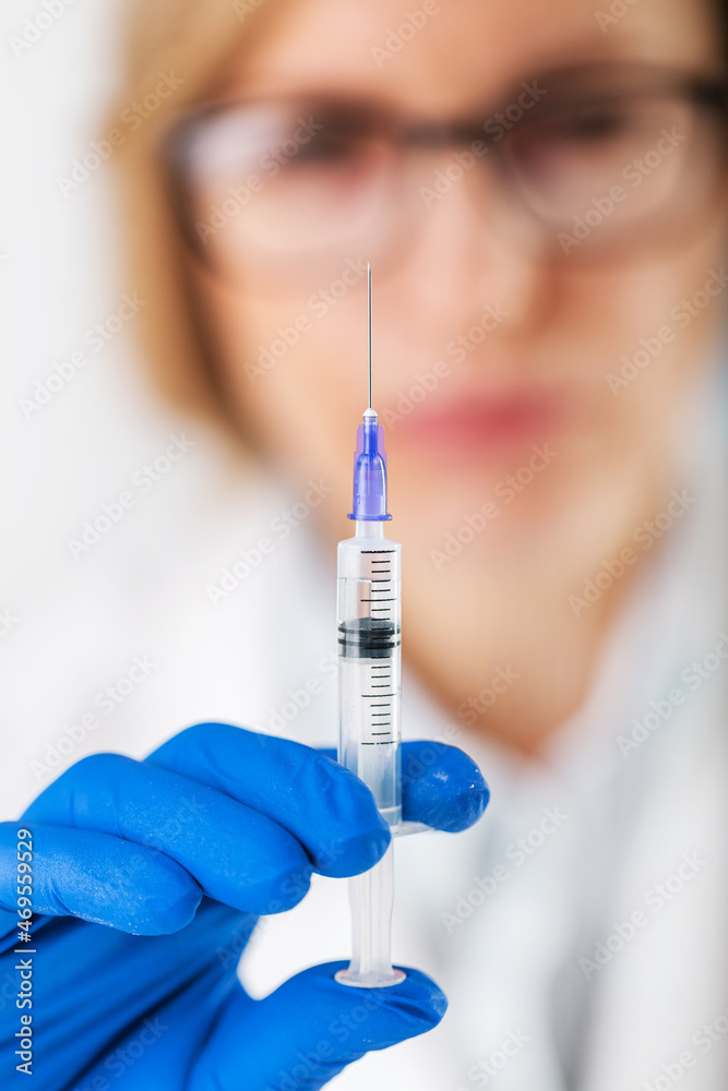 Close up of female medical worker in rubber gloves holding in hands sterile syringe with vaccine. Concept of protection, pandemic and immunity. Close up of female medical worker in rubber gloves holding in hands sterile syringe with vaccine. Concept of protection, pandemic and immunity.