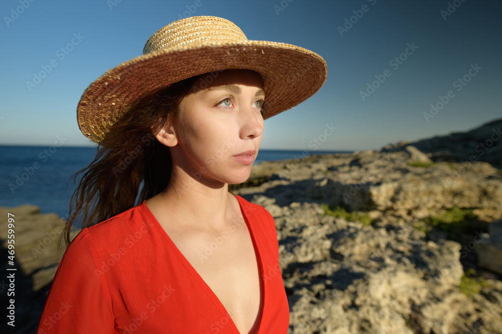 Portrait of a sad tear-stained girl, on a rocky shore with the sea in the background