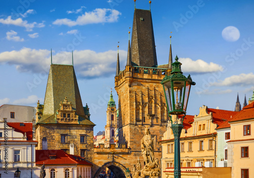Morning at Charles Bridge in Prague, Czech Republic. Solitary road with statues and paving stones. Antique medieval tower and arch of entrance to the old town Mala Strana district downtown. photo