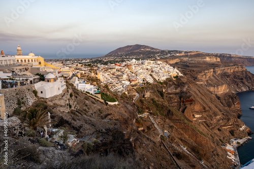 The whitewashed town of Fira in warm rays of sunset on Santorini island, Cyclades, Greece