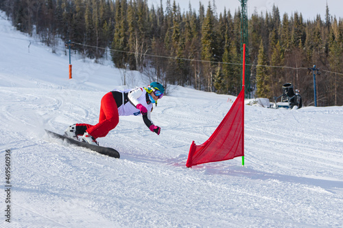 athlete girl with a hard snowboard for slalom in a ski resort enters the turn, Murmansk region, Russia. photo
