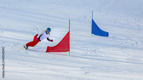 Photography athlete girl with a hard snowboard for slalom in a ski resort enters the turn, Murmansk region, Russia