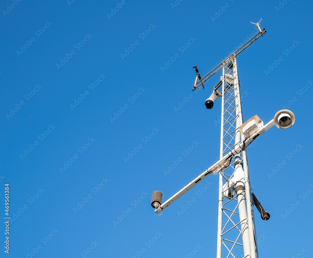 Weather station tower on bright blue sky background with modern technology equipment Weather station tower on bright blue sky background with modern technology equipment