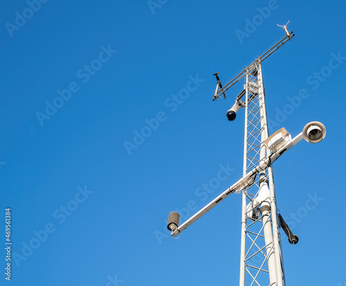 Weather station tower on bright blue sky background with modern technology equipment