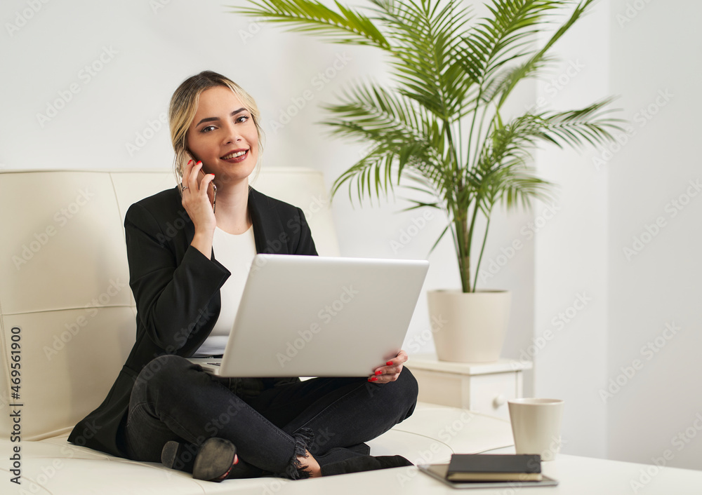 young woman talking on her smartphone while having coffee before starting work young woman talking on her smartphone while having coffee before starting work