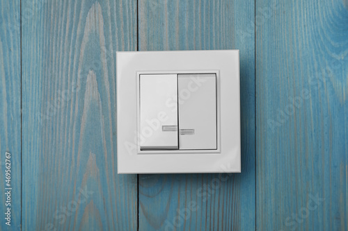 White light switch on turquoise wooden background