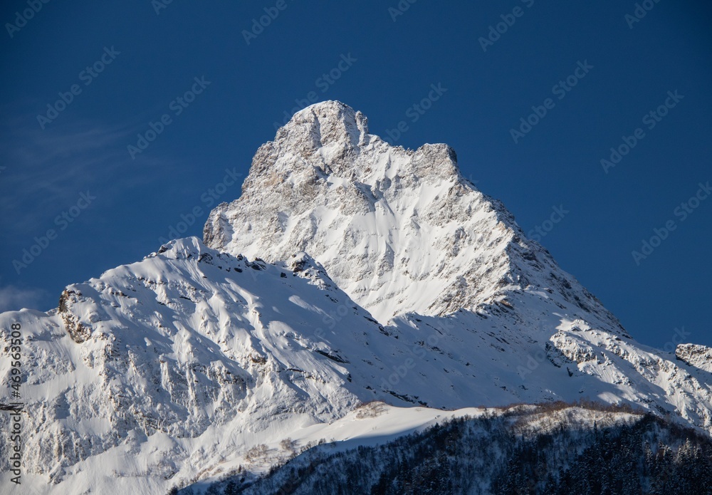 Snowy Mountains peaks and clear blue sky
