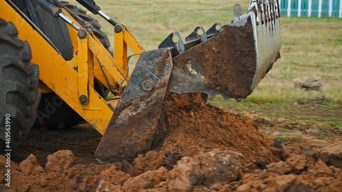 Earthworks in the countryside. Modern bulldozer burying a trench at a construction site. Summer cloudy day