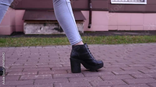 A girl in high-heeled shoes walks down the street. Bottom view. Close-up.