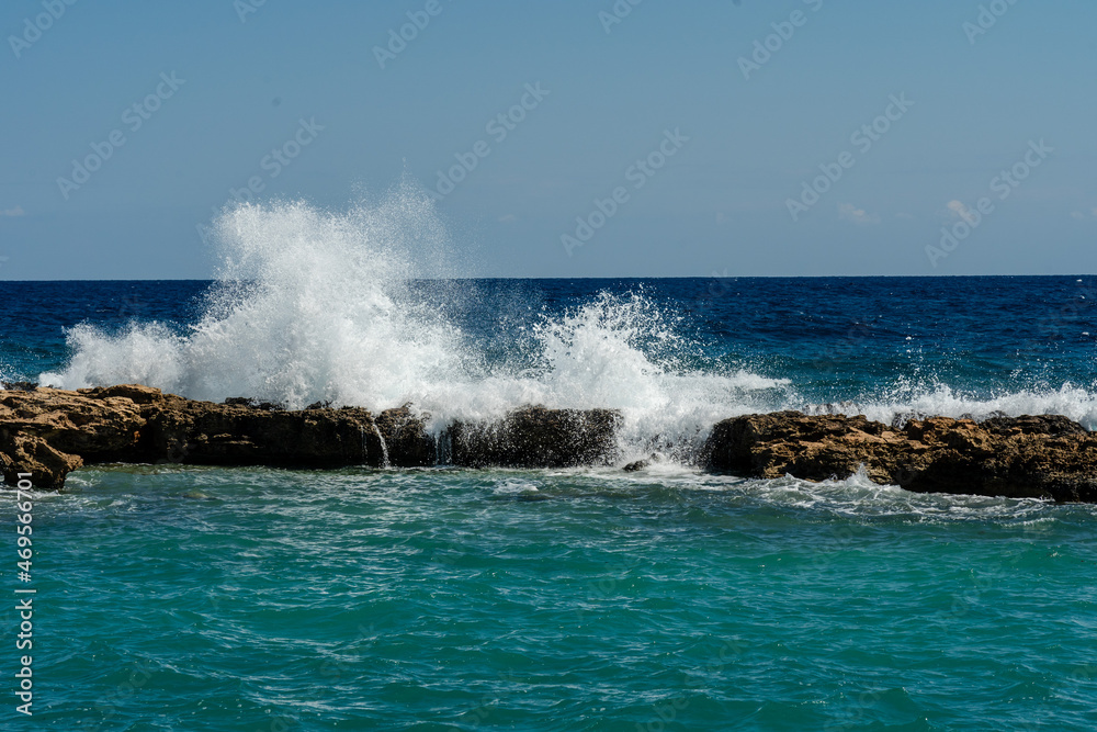 Sea waves break at rock during storm