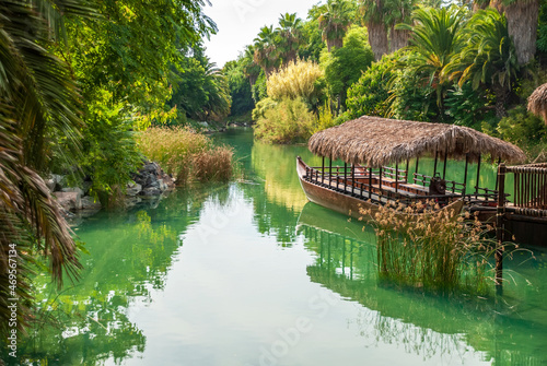 Tropical landscape. Lagoon with clear turquoise water rainforest and ancient boat made of wood.