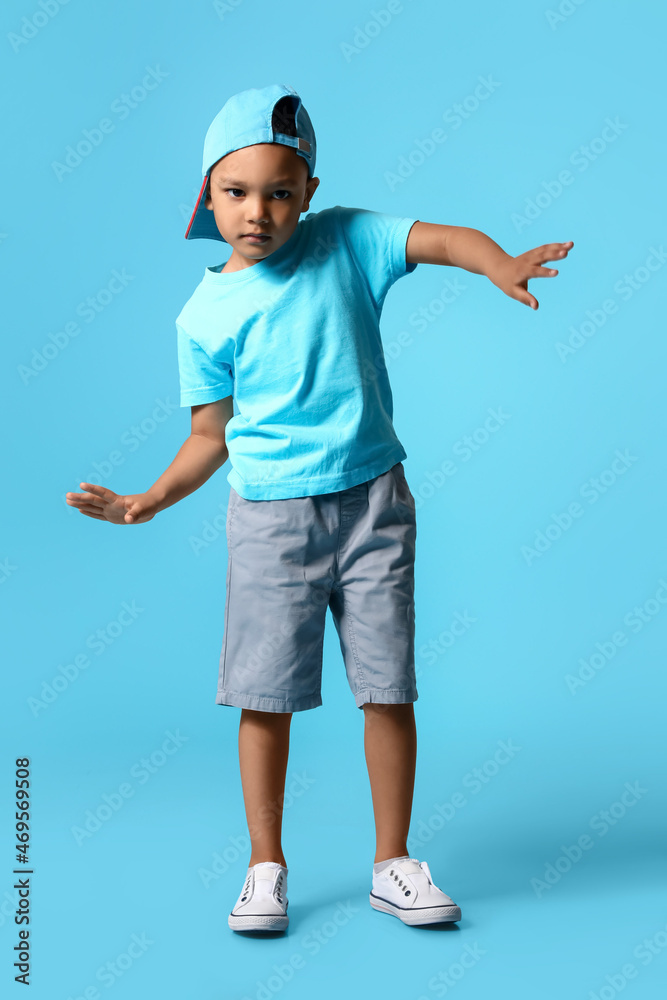 Cute dancing African-American boy on color background