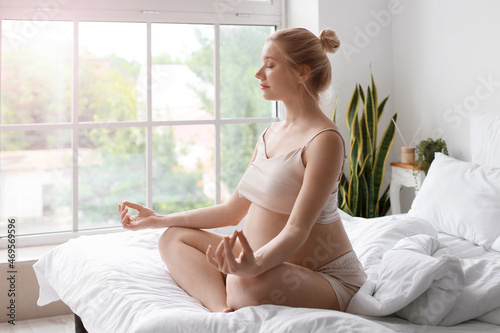 Young pregnant woman meditating on bed at home Free Download Young pregnant woman meditating on bed at home - GFXLoad