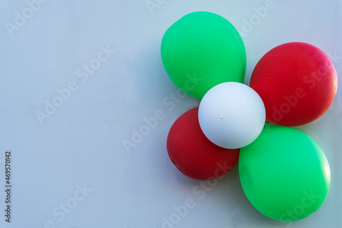 Colorful balloons on the light wall of the building  red  white and green balloons on a light background