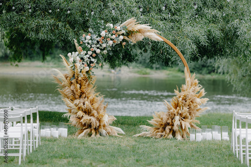 The round wedding arch on the background of the river and greenery photo