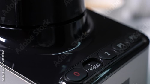 Woman presses button Ice Crush on blender and ice begins to crush. Then crushing is done, woman turns off the blender. Close-up. High quality 4k footage