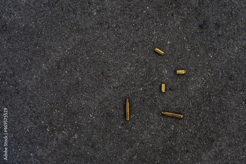 Two different caliber bullet shell casings on asphalt street photo