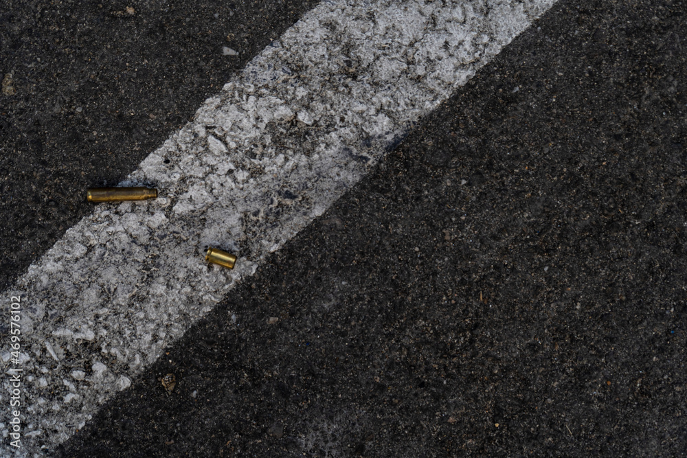 Fototapeta premium Two different caliber bullet shell casings on asphalt street