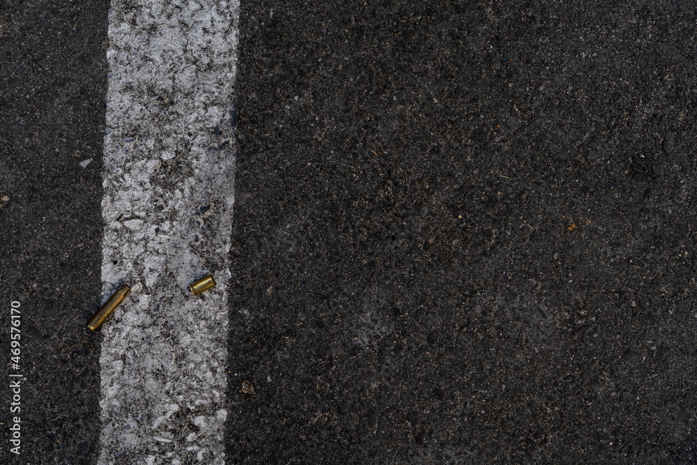 Fototapeta premium Two different caliber bullet shell casings on asphalt street