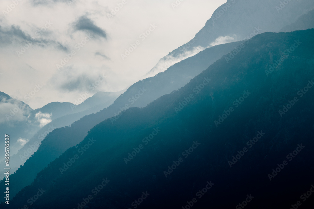 Mountain silhouettes. Misty mountain silhouette with clouds in full frame