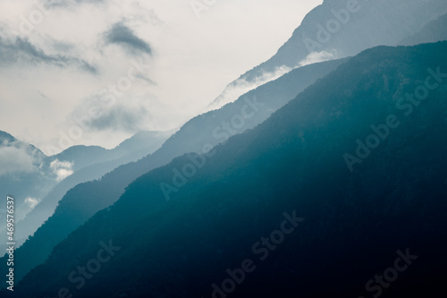 Mountain silhouettes. Misty mountain silhouette with clouds in full frame