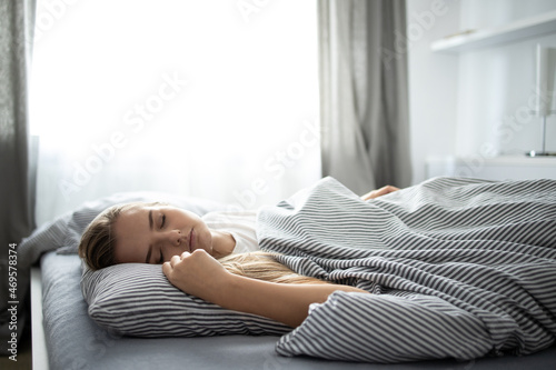 Pretty, young woman sleeping in her bed with her cell phone close to her. Smartphone in Bed Mobile/smartphone Addiction Concept.