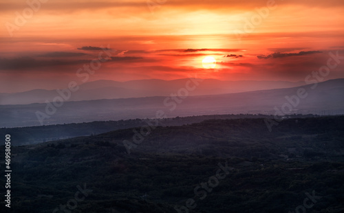 Sunset with layers of hills and mountains, soft focus. Mountain layers in sunset. Blue mountains and last sun lights landscape. © Ivan