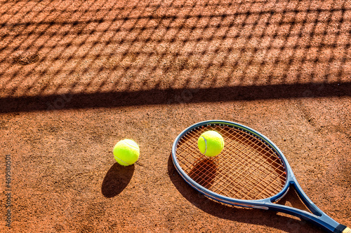 Tennis racket and new tennis ball on a Red clay court.  © Ivan