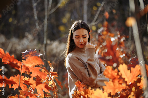 portrait of a woman against the background of an autumn forest on a sunny day