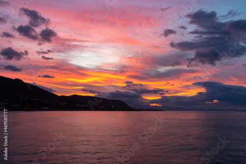Cefalù Sunset Brilliance. The sun dips below the horizon in Cefalù, painting the sky with vibrant hues of orange and pink, reflecting its brilliance over the calm waters.