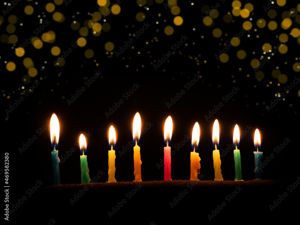 Hanukkah is a Jewish religious holiday of candles. Nine burning candles on a dark background. The Feast of Fire and Light Hanukkah is a Jewish religious holiday of candles. Nine burning candles on a dark background. The Feast of Fire and Light