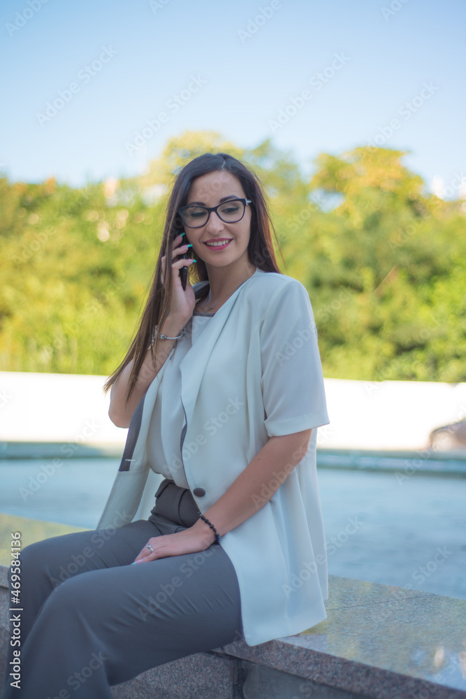 Smiling business girl talking on mobile phone. The concept of a business woman. Smiling business girl talking on mobile phone. The concept of a business woman.