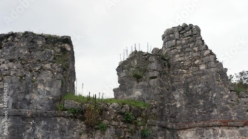 Ruins of a castle - stone walls of medieval fortress. Derelict historical building, aged and neglected. Archaeological site of ancient city Lesendro in Europe - famous heritage of civilization.  photo