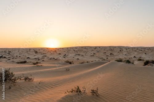 A stunning sunset over the Oman desert  with sand dunes against the orange sky