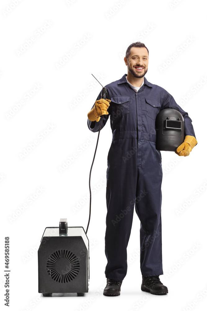 Full length portrait of a welder in a uniform holding a welding generator and  face shield - obrazy, fototapety, plakaty 