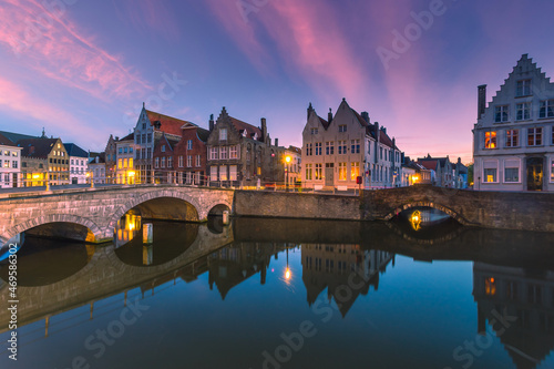 Historic medieval buildings along a canal in Bruges during amazing sunset, Belgium