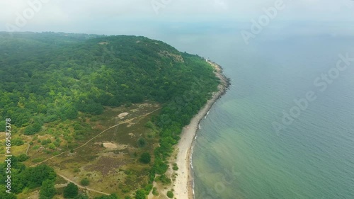 Sandy beach along forest shoreline, aerial view of Stenshuvud national park in Sweden photo