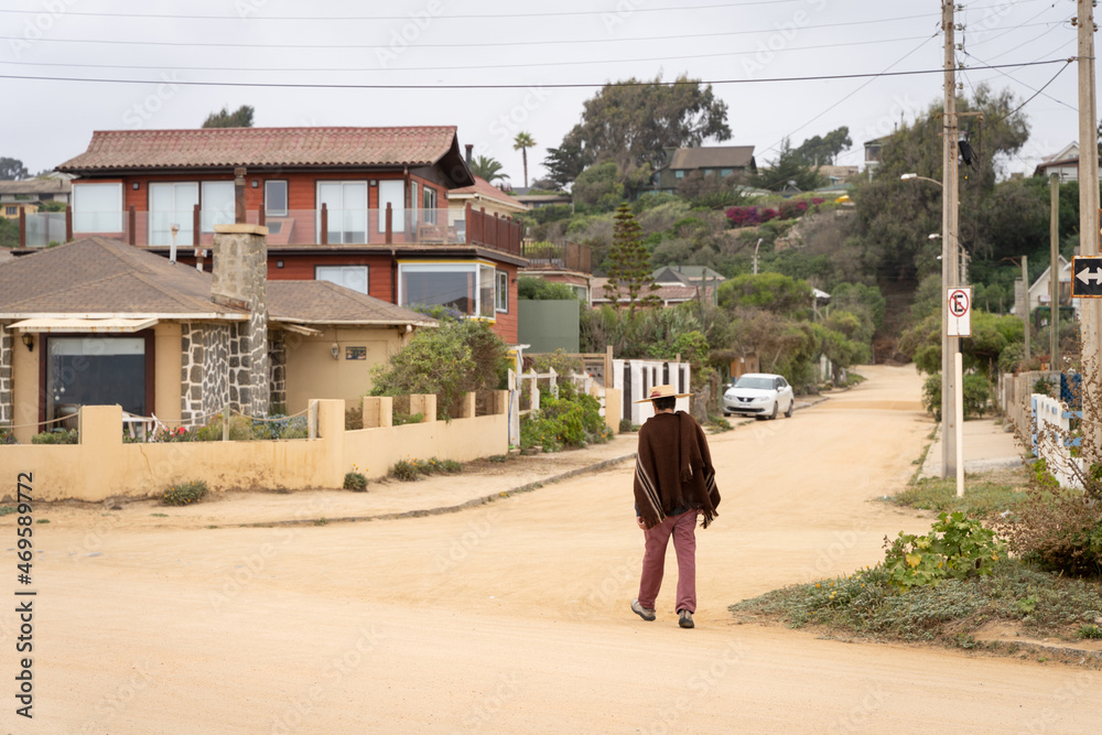 Lonely peasant man walking on empty unpaved street during Covid-19 pandemic in Algarrobo, Chile