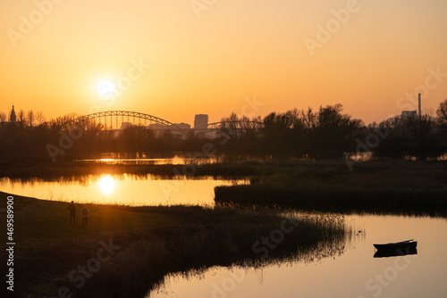 Setting sun behind the bridge over the Waal (Rhine) river in Nijmegen against an orange evening sky © Jeroen Kleiberg