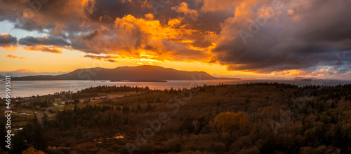 Fiery Red Sunset Over Orcas Island, Washington. After a torrential rain storm the clouds finally opened up and as the sun set it turned the clouds bright red and orange. Aerial taken from Lummi Island