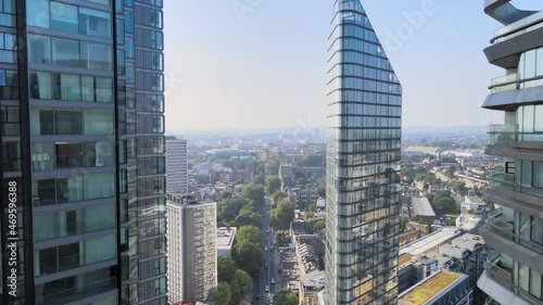 Elevated fly around tops of modern apartment buildings in town. Revealing panoramic view of urban neighbourhood. London, UK