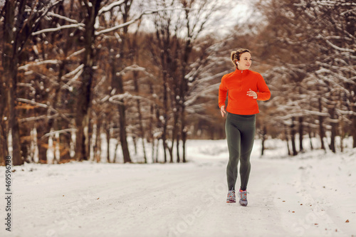 Fit sportswoman running in nature on a snowy winter day. Cold weather, snow, healthy life, fitness, healthy habits © dusanpetkovic1