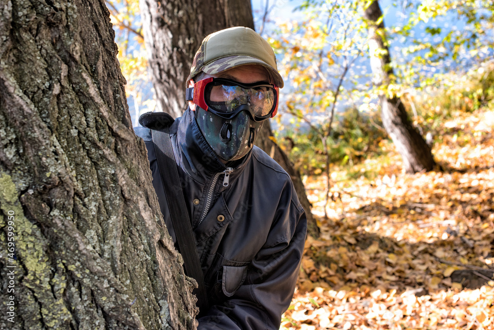 A man wearing respirator mask and protective glasses walking in the forest at COVID-19 period.