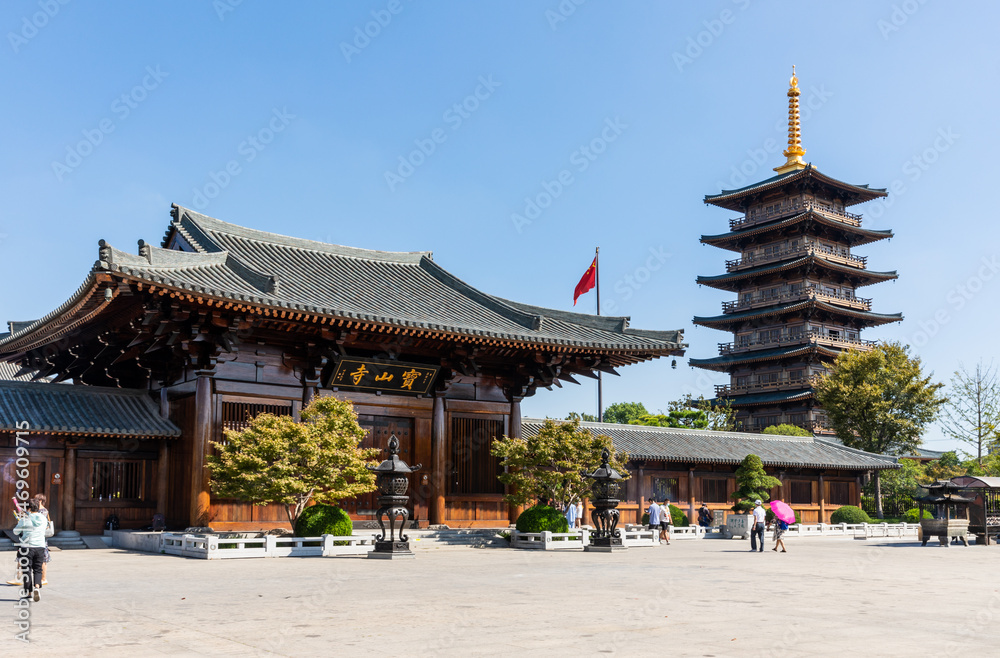 Fototapeta premium Shanmen and pagoda of historic Baoshan or Treasure Mountain Serene Temple, a Buddhist temple on banks of Lianqi River at Luodian Town, Baoshan District, Shanghai, China.