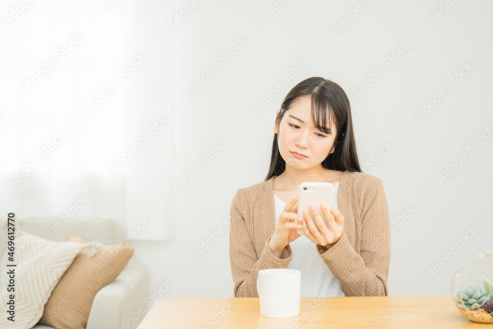 スマホを見る女性(疑問)
スマホを見る女性(疑問)