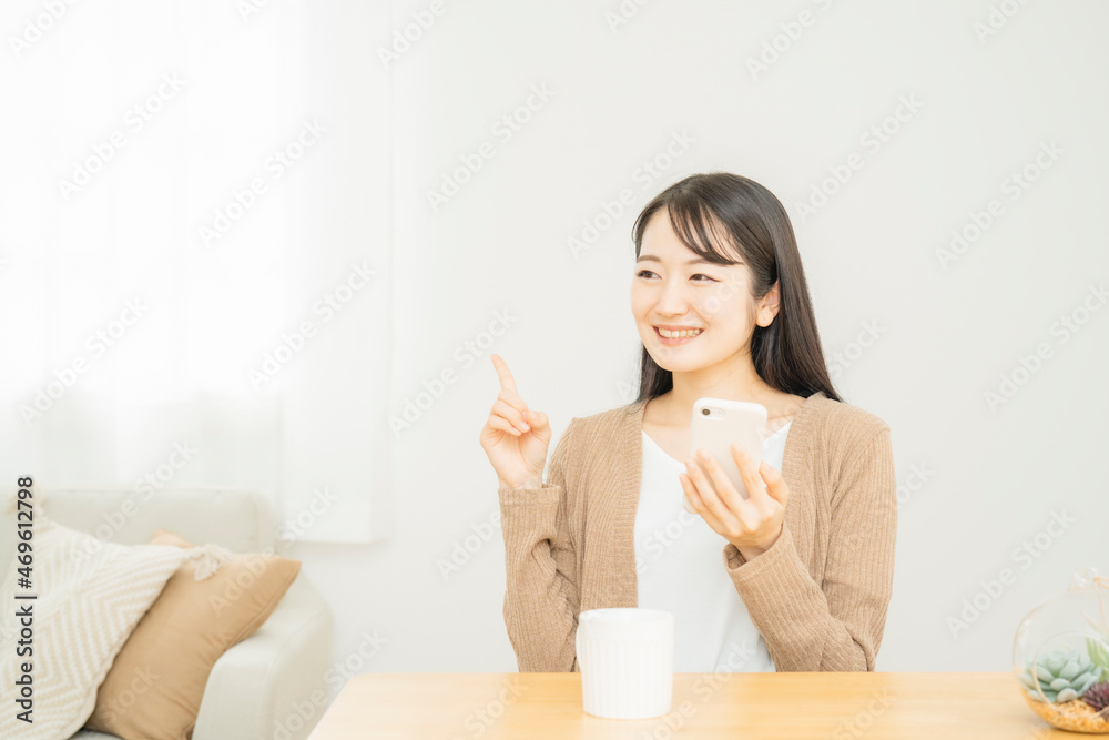 家でスマホを使う女性
家でスマホを使う女性