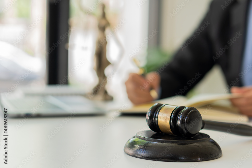 the goddess of justice with scales and hammers placed in front of a Male lawyer working on a laptop legal concept. Advice on Justice in the Lawyer's Office the goddess of justice with scales and hammers placed in front of a Male lawyer working on a laptop legal concept. Advice on Justice in the Lawyer's Office