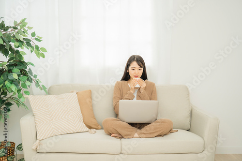 ノートパソコンで何かを見る女性（驚く） 