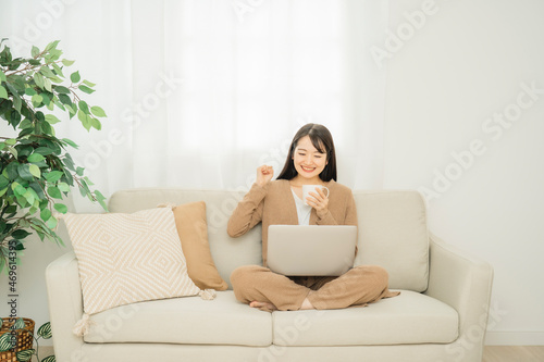 ノートパソコンに向かって応援する女性
