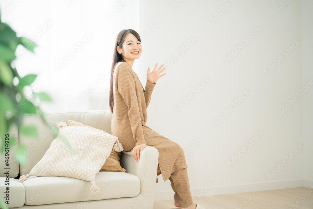ソファのヘリに座る女性（同棲）

